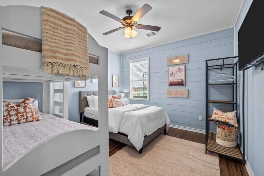 Front bedroom includes one double bed and a twin bunk bed. The room includes a smart TV and storage.