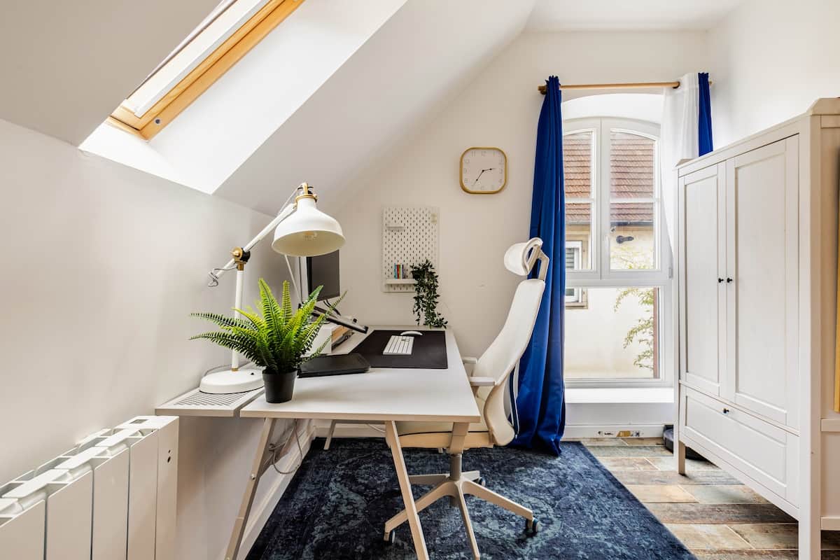Un espace de travail lumineux avec un fauteuil ergonomique, un grand écran et une connexion fibre