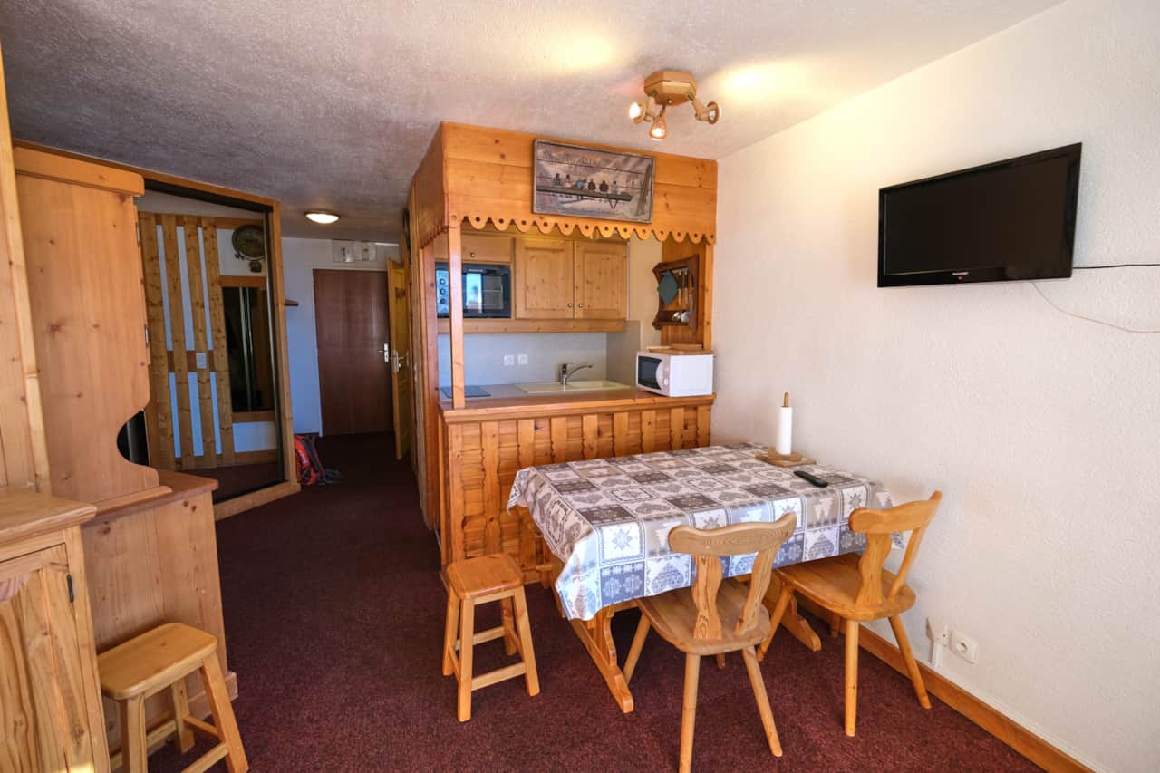 Coin repas avec télévision et cuisine en bois — Les Névés, Val Thorens