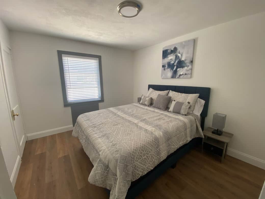 Bright bedroom with a queen bed, premium linens and cozy bedside lamps. Lakeland, FL