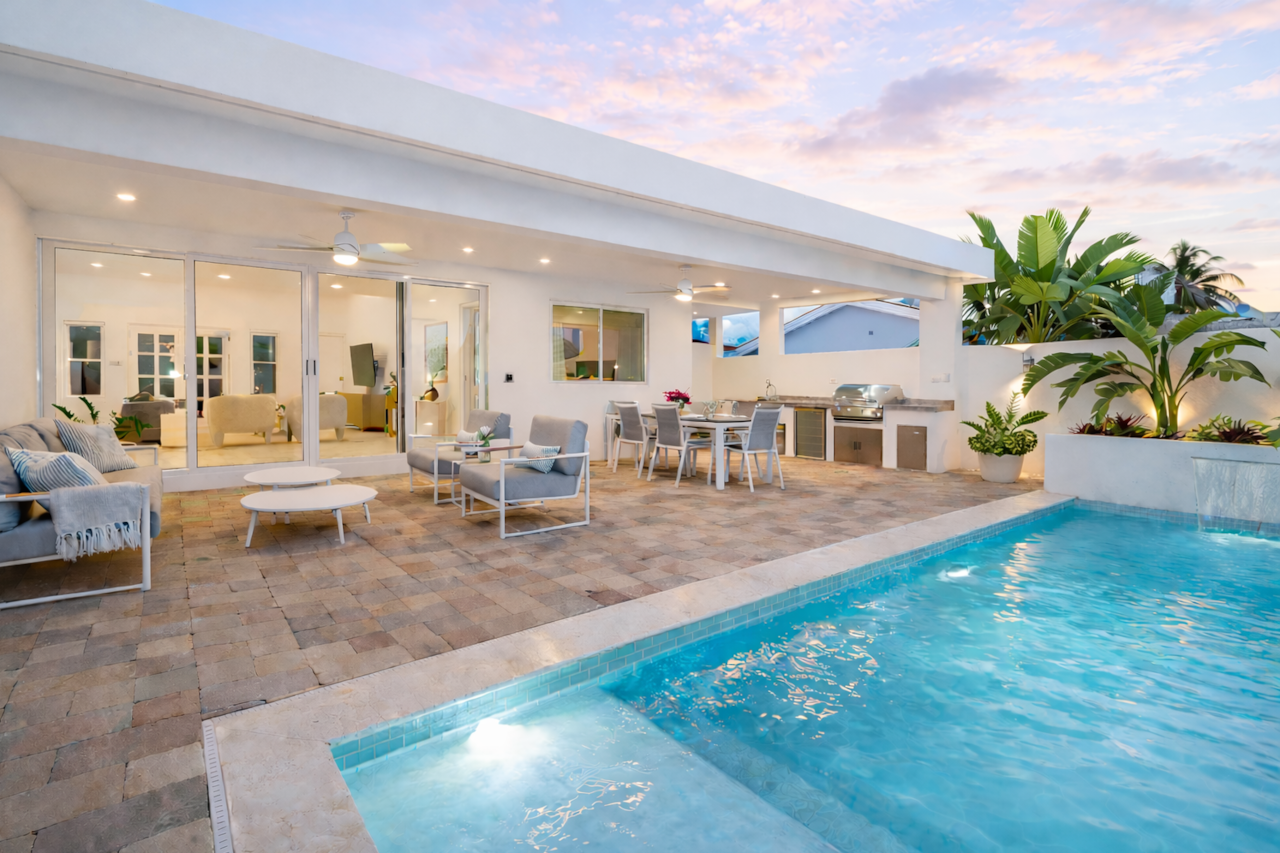 Private backyard with pool and covered lounging, dining, and BBQ areas 