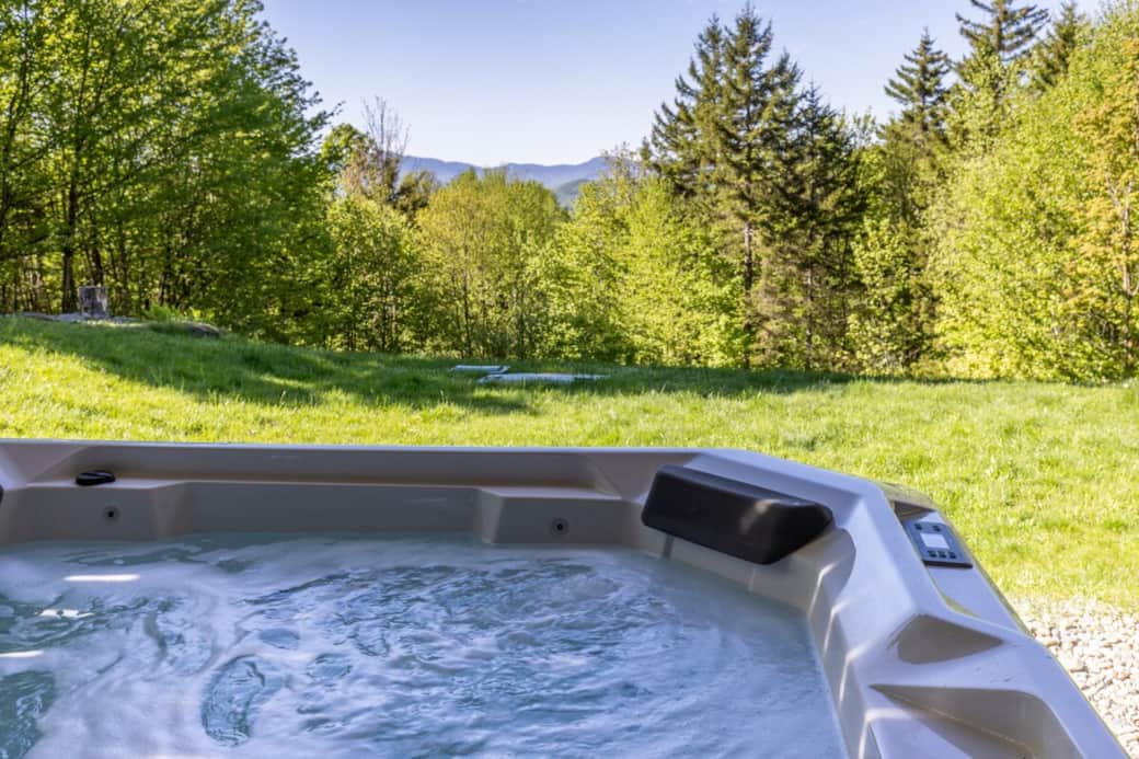Soak in the hot tub surrounded by peaceful greenery and mountain views