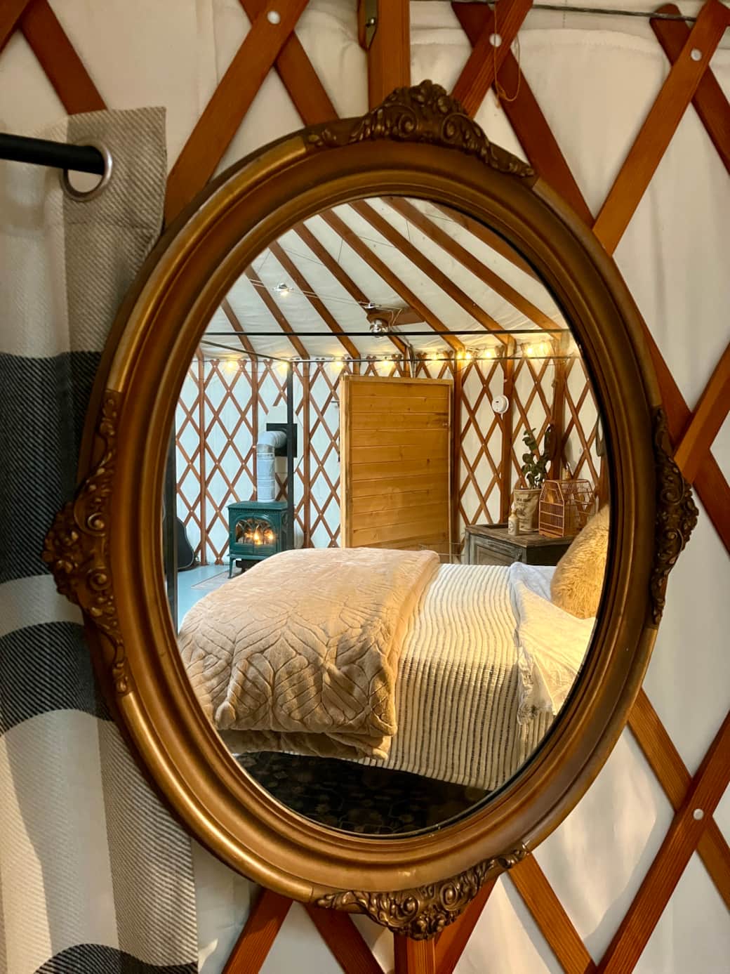 Cozy interior of the yurt reflected in the vintage mirror.