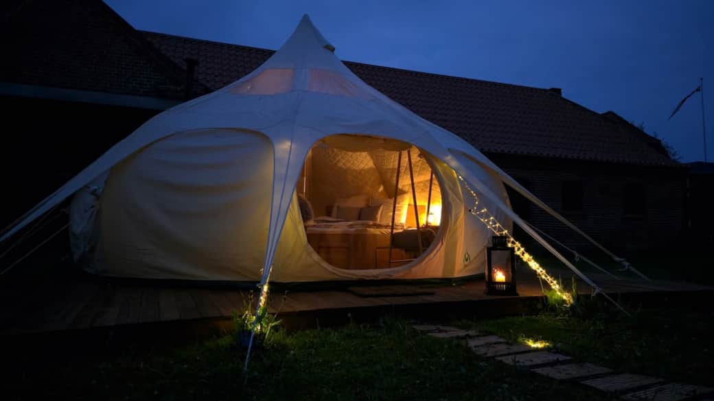 Romantische Stimmung: Das Lotus-Belle-Zelt erleuchtet bei Nacht am Limfjord.