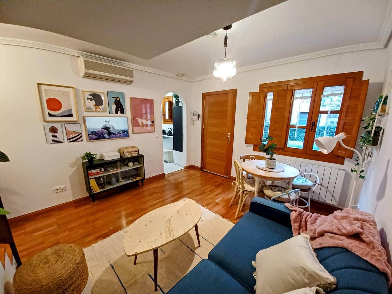 Salón amplio con ventanas de madera y mesa de centro