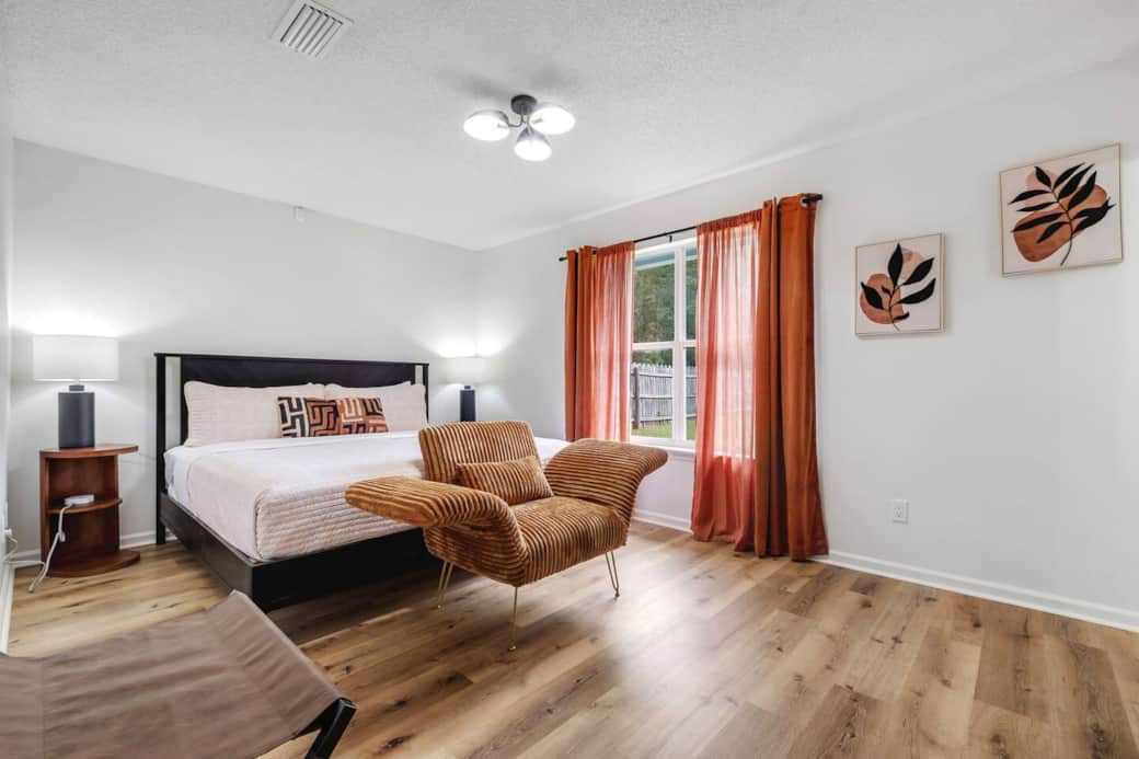 Primary bedroom with gorgeous king bed, smart TV, stunning comfy chair and a luggage rack to save the bedding from those dirty luggage wheels.  Also has a large walk in closet (not pictured).
