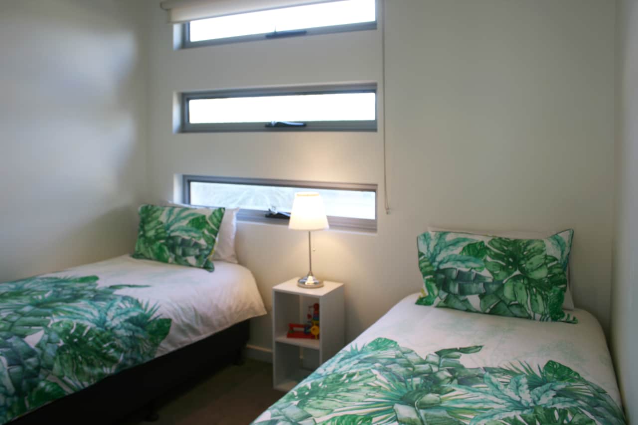 Two single beds in room next to king size bedroom 
