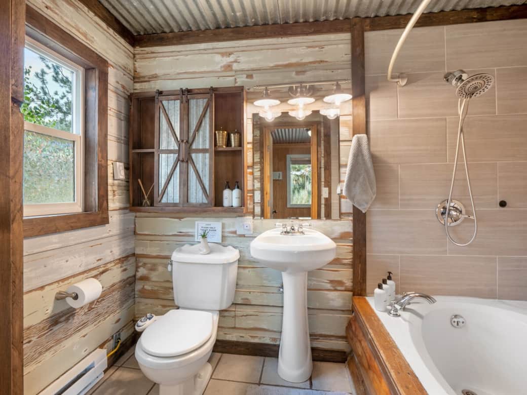 Upstairs bathroom with a large soaking tub and reclaimed barn wood decor. 