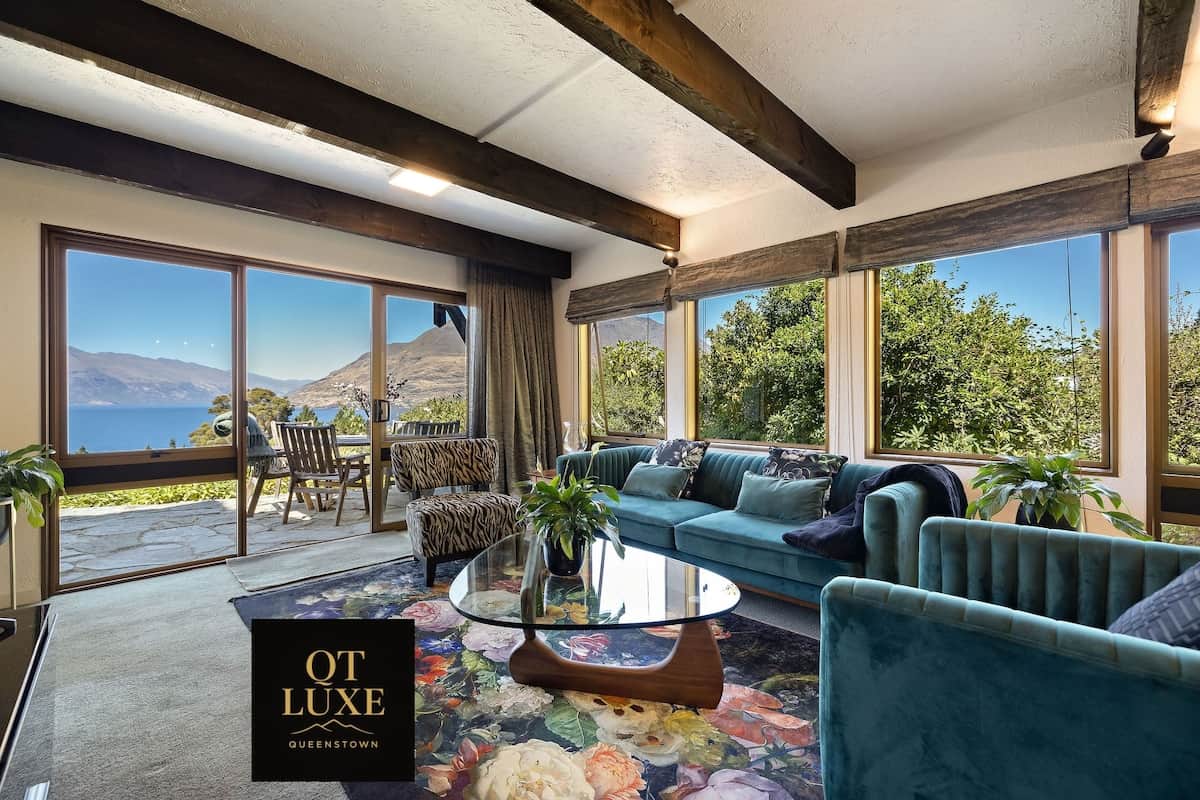 Lake and mountain views through large windows with outdoor seating at Walk to Town 39A Alpine Chale