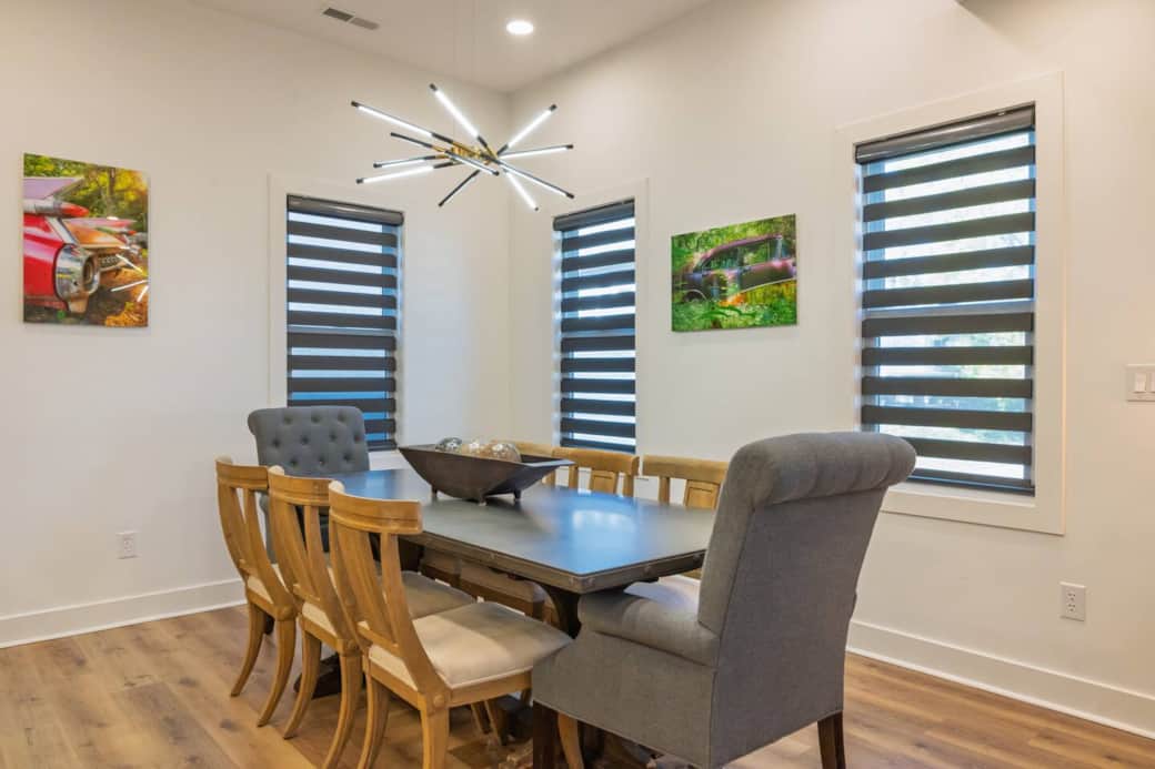 Restoration Hardware dining room set featuring distressed pine trestle base table with a zinc top. Six drifted oak side chairs upholstered in Belgian linen and two grey linen armchairs.