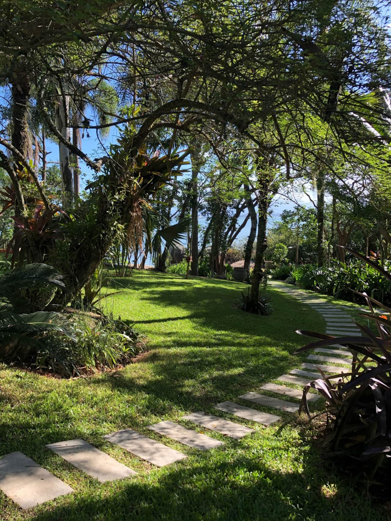 Caminho no jardim que dá acesso a uma praia quase particular