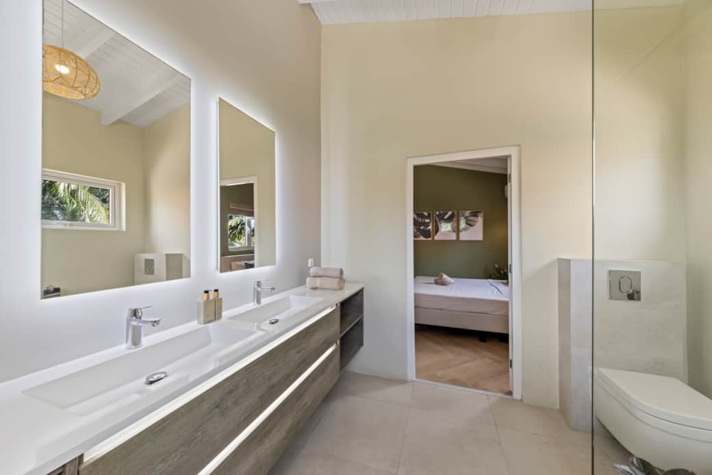 Ensuite badkamer behorend bij master bedroom 1, voorzien van dubbele wastafel, toilet en spa douche Ensuite badkamer behorend bij master bedroom 1, voorzien van dubbele wastafel, toilet en spa douche