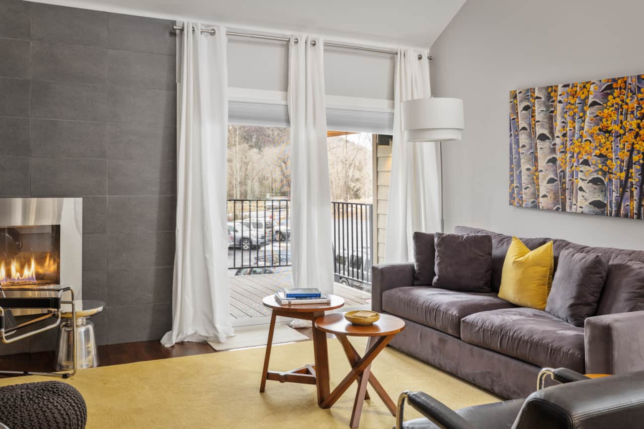 The living room features a private deck with mountain views