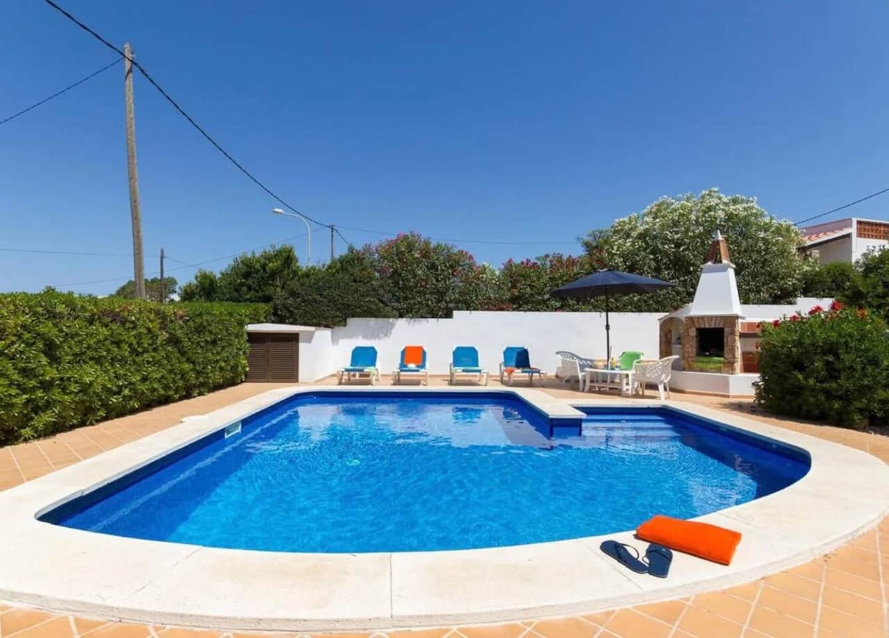 Pool and patio with sun loungers and umbrella