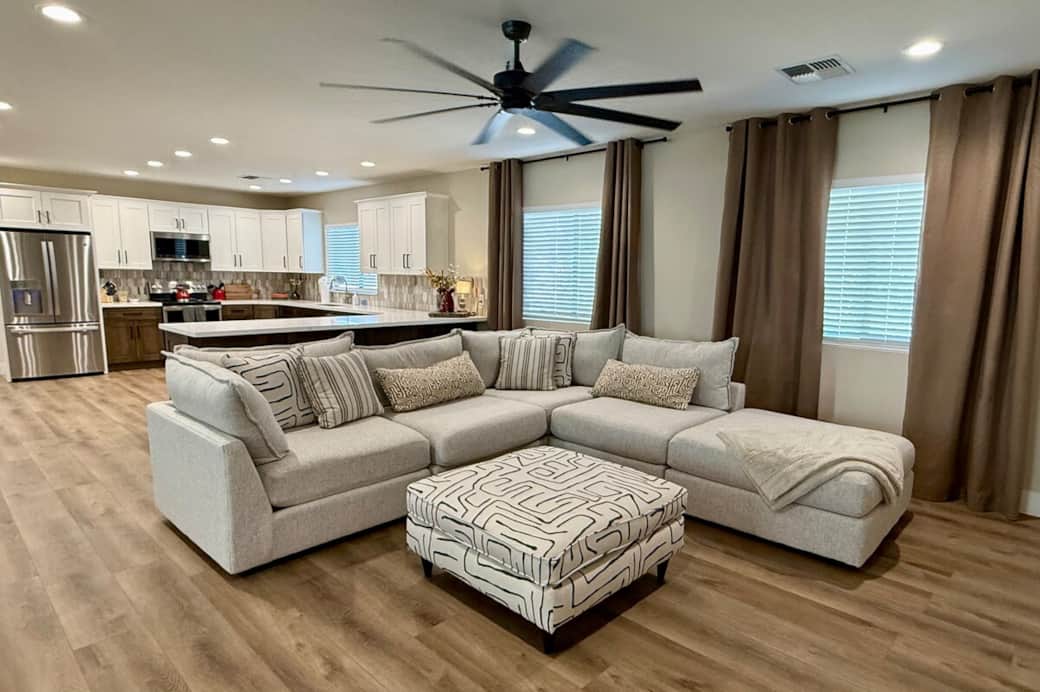 This open concept living room is the heart of the home. It is complete with a large smart tv, dedicated workspace and adjacent to the kitchen and dining room.