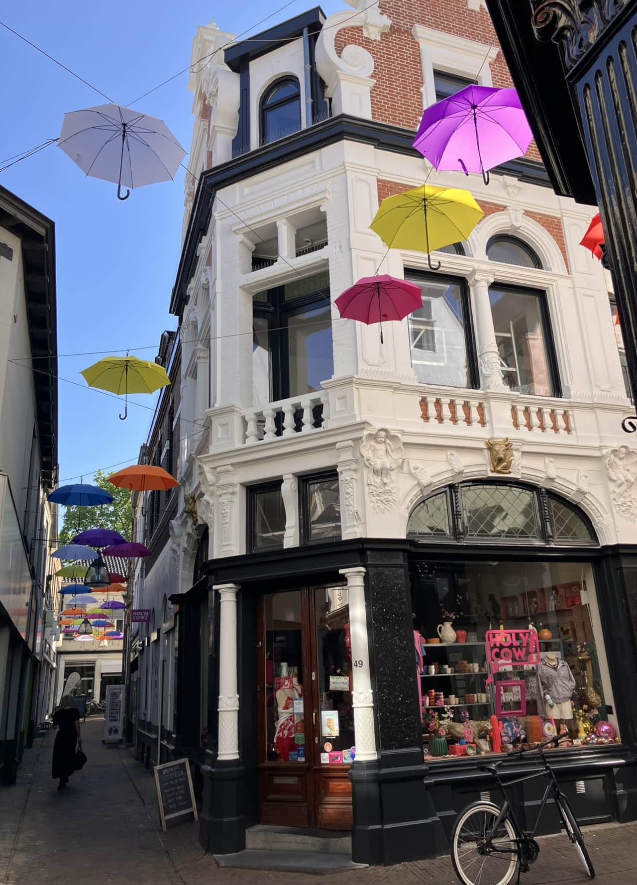 Exterior of the Gilded Ox Suites building in Deventer's city centre, with colourful umbrellas overhe