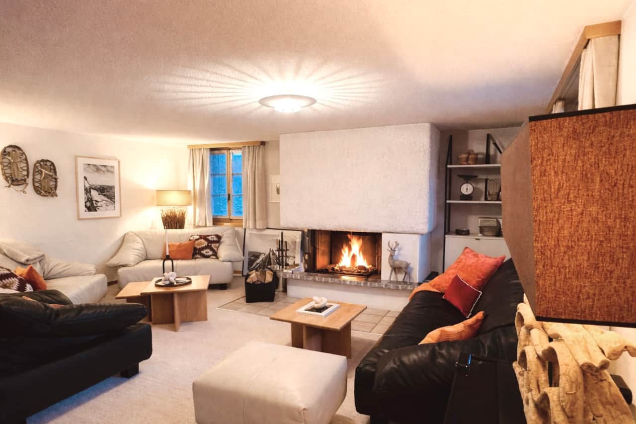 Salon avec canapé, cheminée et accès direct au balcon.