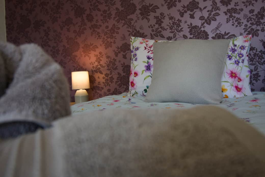 Cosy and inviting bedroom with soft furnishings and warm lighting