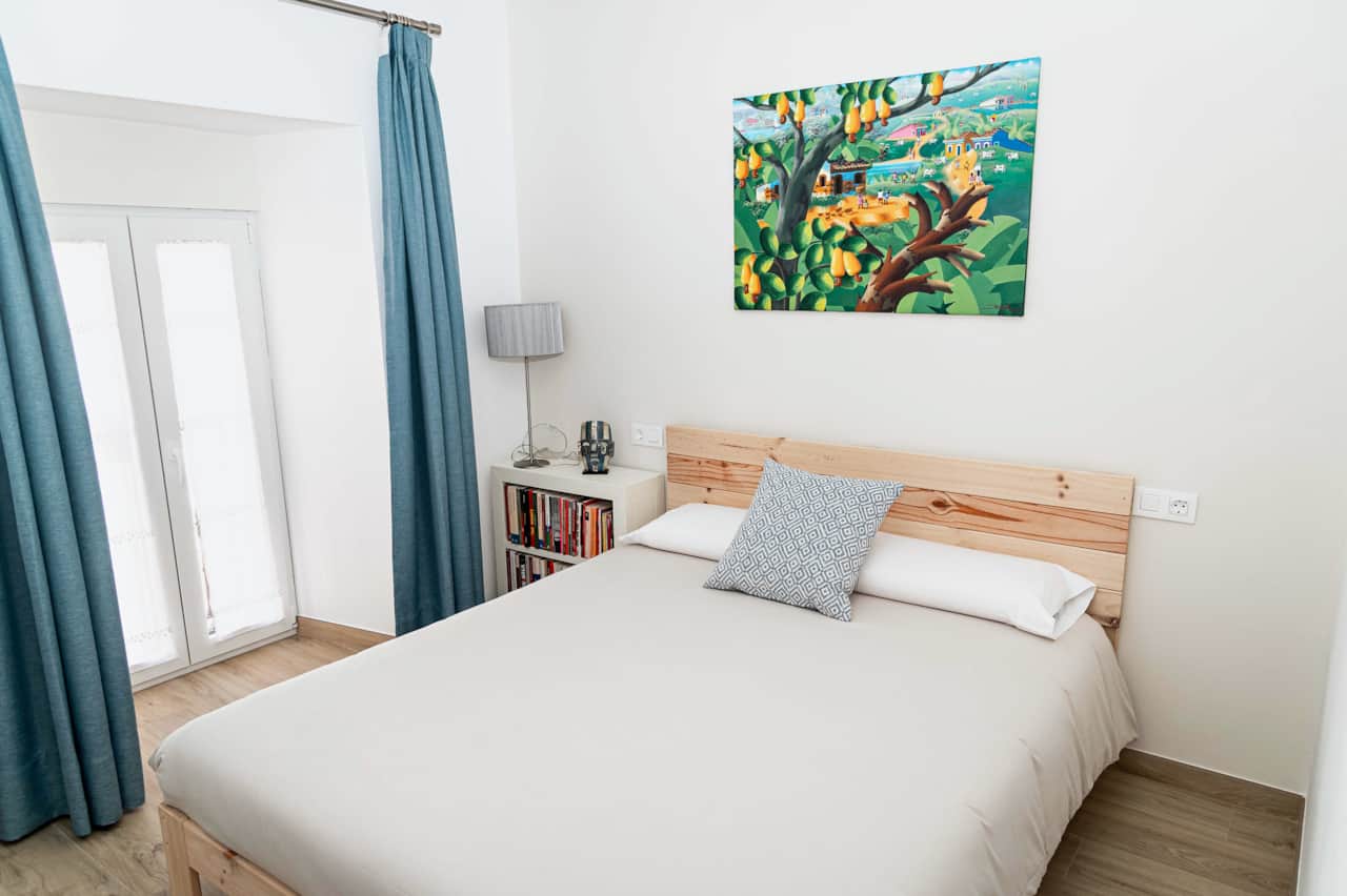 Dormitorio con cama de matrimonio y balcón