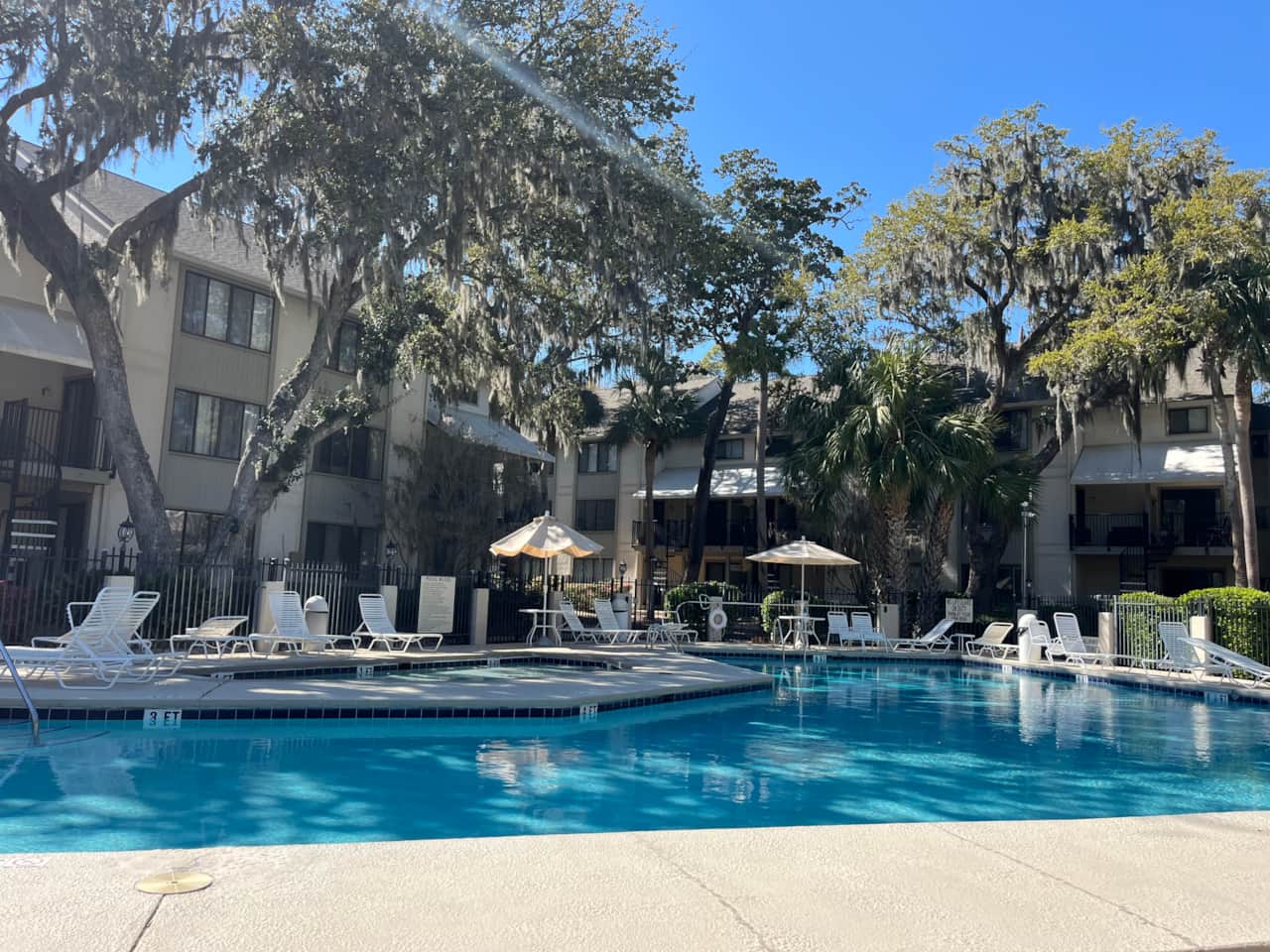 Community pool with lounge chairs and umbrellas at Springwood, Forest Beach Hilton Head