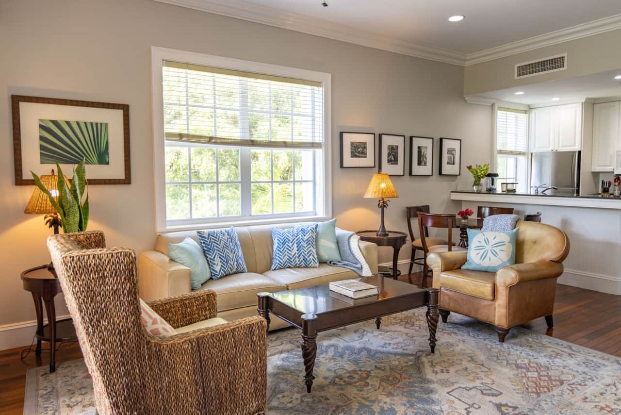 Bright living room with sofa, armchairs, coffee table and a garden view window