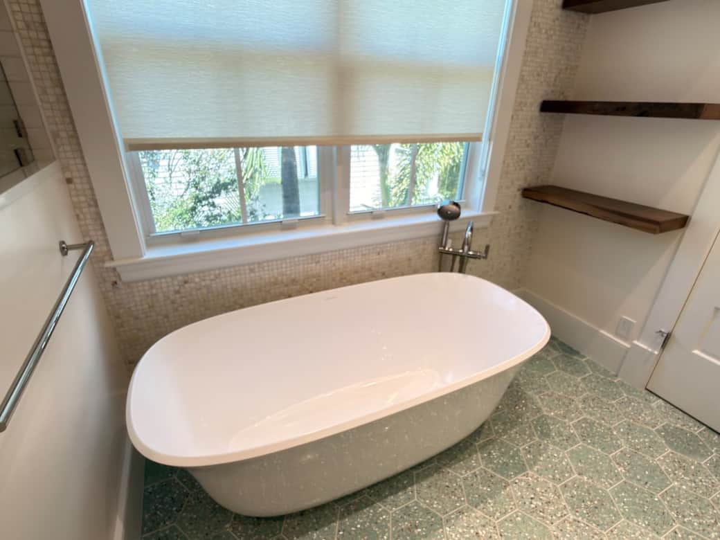 A spacious, spa-like en-suite bath featuring a walk-in shower, soaking tub, and his and hers vanity. Finished in a refined coastal-modern style, it offers a bright, luxurious setting designed for comfort, relaxation, and privacy.
