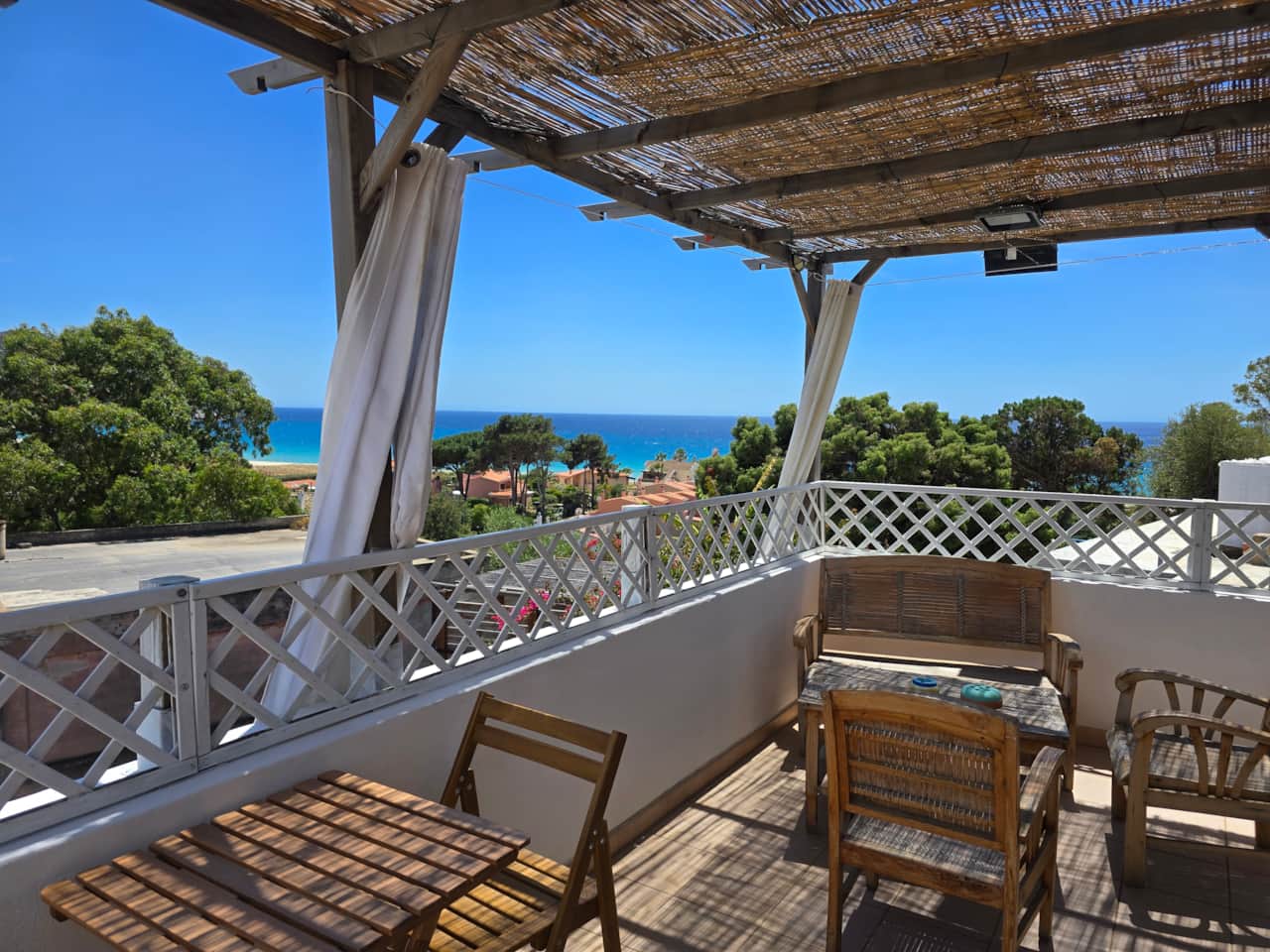 Sea-view dining beneath the shaded pergola