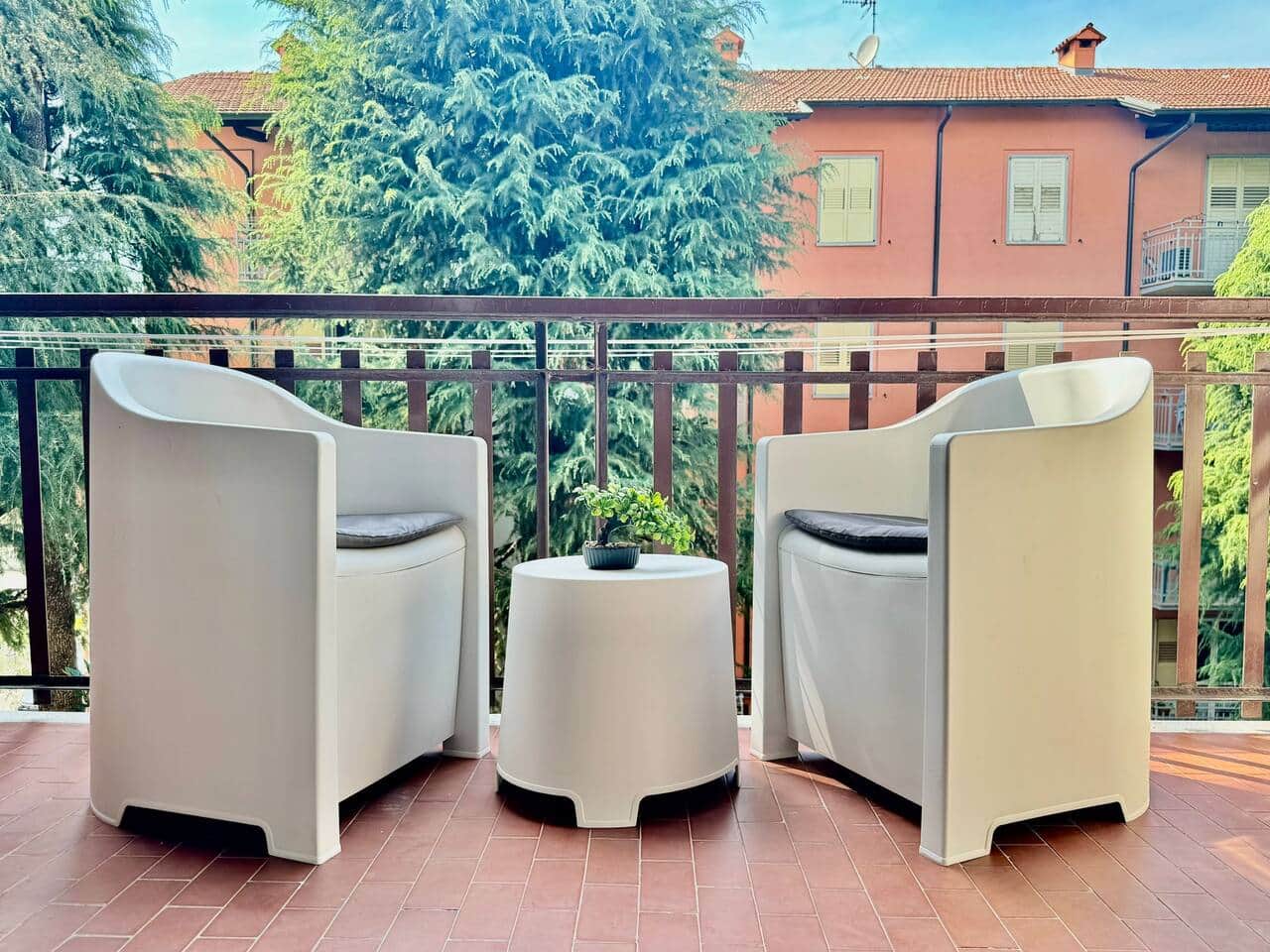 Balcone attrezzato con poltroncine e tavolino, affacciato sul verde, ideale per colazioni all’aperto o momenti di relax.