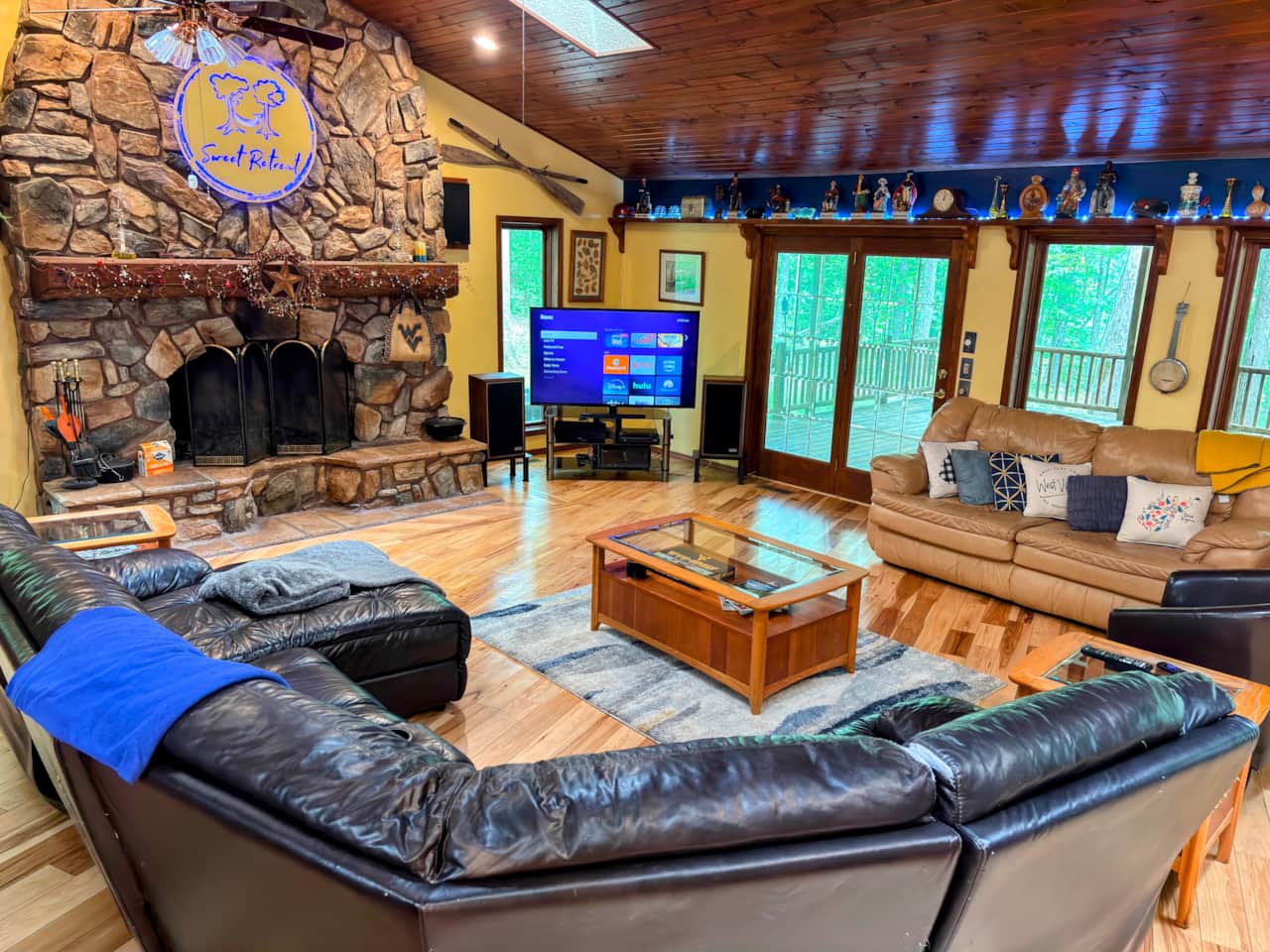Spacious great room with a fireplace and views of nature. Glass doors flood the room with light.