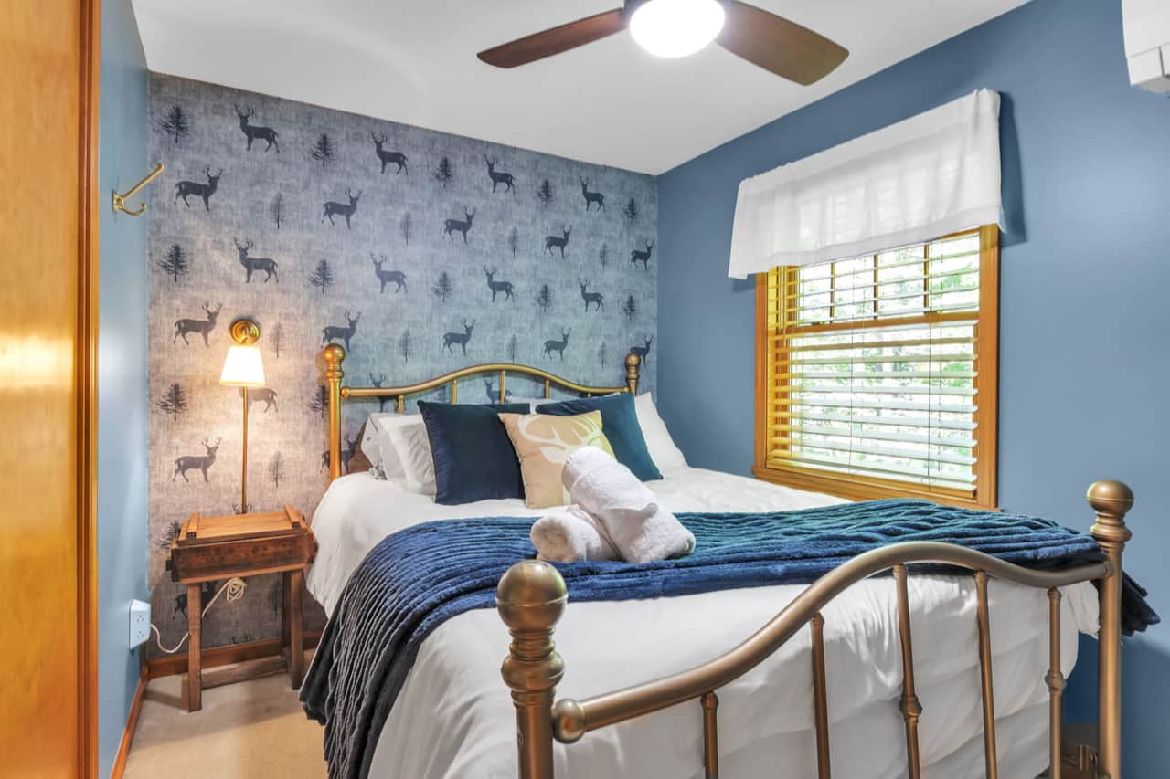 Cozy queen primary bedroom with peaceful woodland-inspired décor