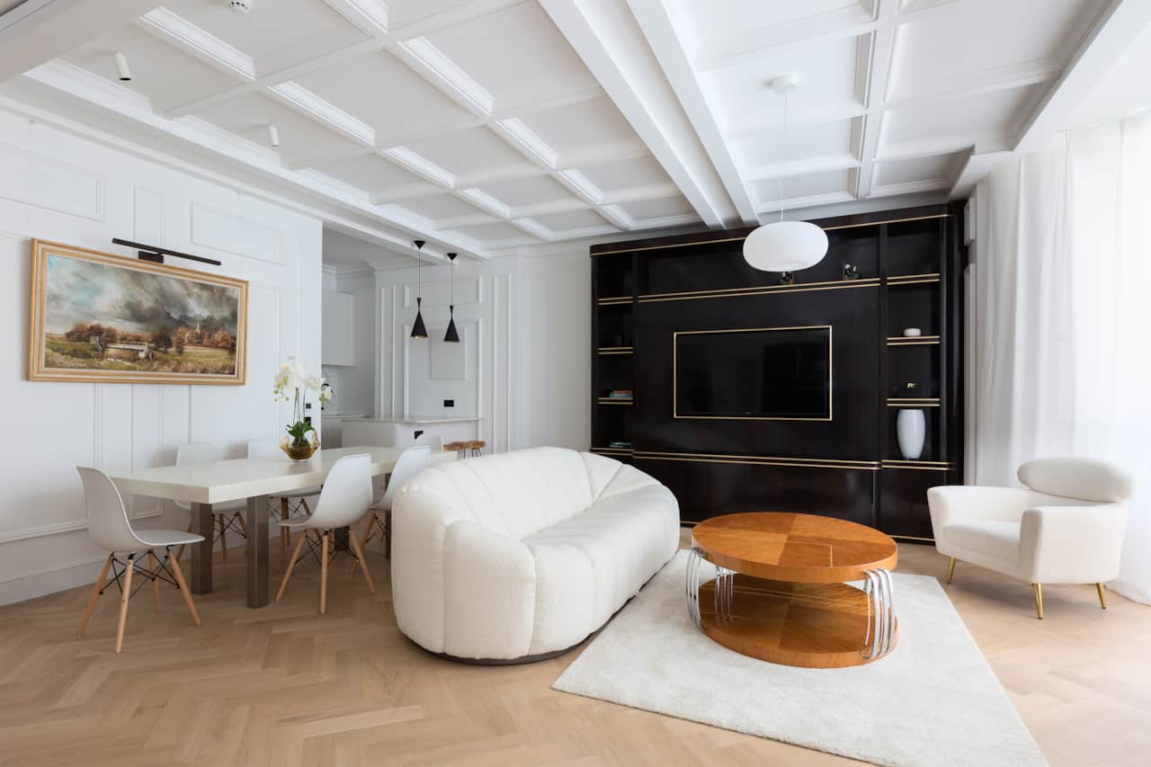 Open-plan living and dining space with statement artwork and boucle sofa