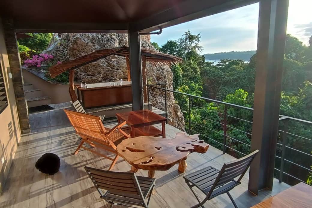 The lower veranda looking out to the ocean over the green tropical canopy,  accommodating  2 guest rooms with a bathroom at the lower level. It is accessed through an exterior stairway and not so suitable for PWD. The lower veranda looking out to the ocean over the green tropical canopy,  accommodating  2 guest rooms with a bathroom at the lower level. It is accessed through an exterior stairway and not so suitable for PWD.