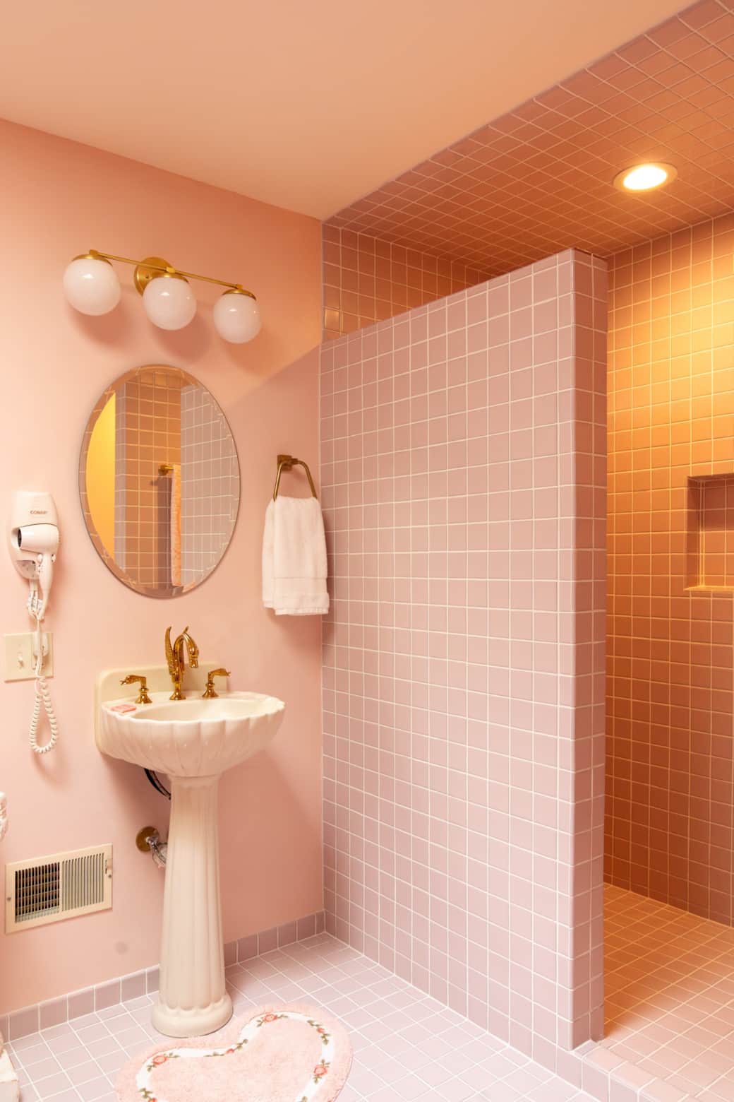 Pedestal sink with Swan faucet and pink shower tile Pedestal sink with Swan faucet and pink shower tile