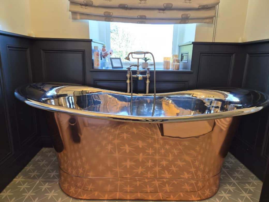 Large freestanding copper bath designed for two
