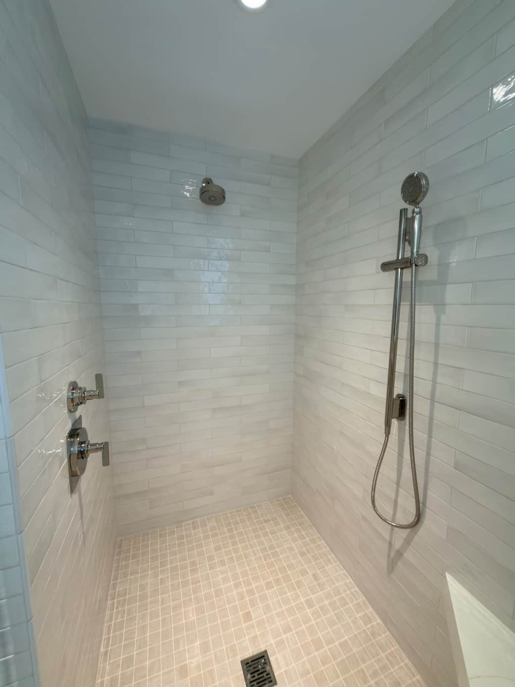 A spacious, spa-like en-suite bath featuring a walk-in shower, soaking tub, and his and hers vanity. Finished in a refined coastal-modern style, it offers a bright, luxurious setting designed for comfort, relaxation, and privacy.