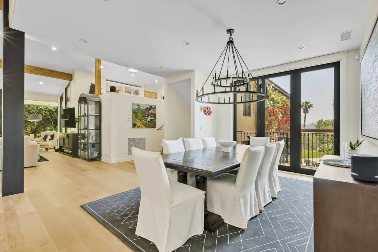 Enjoy memorable meals in the dining area of this extraordinary house, where sunlight fills the space, creating a warm and inviting ambiance with a scenic outside view.
