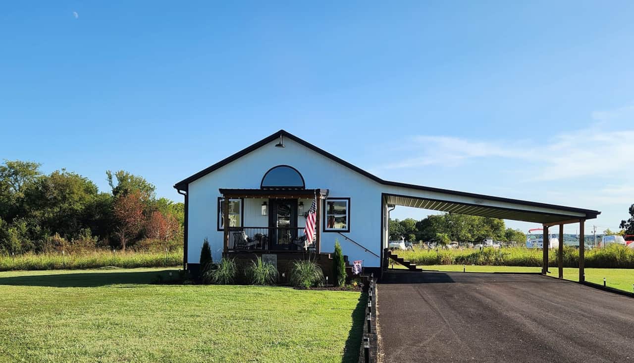 Exterior of home with ample parking for cars, truck, and trailer.