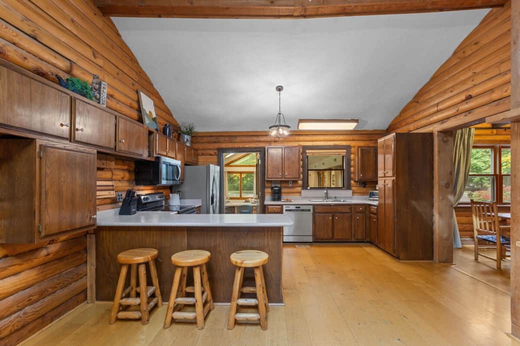 Fully equipped kitchen with wood cabinetry, modern appliances, and a breakfast bar with seating for casual dining.