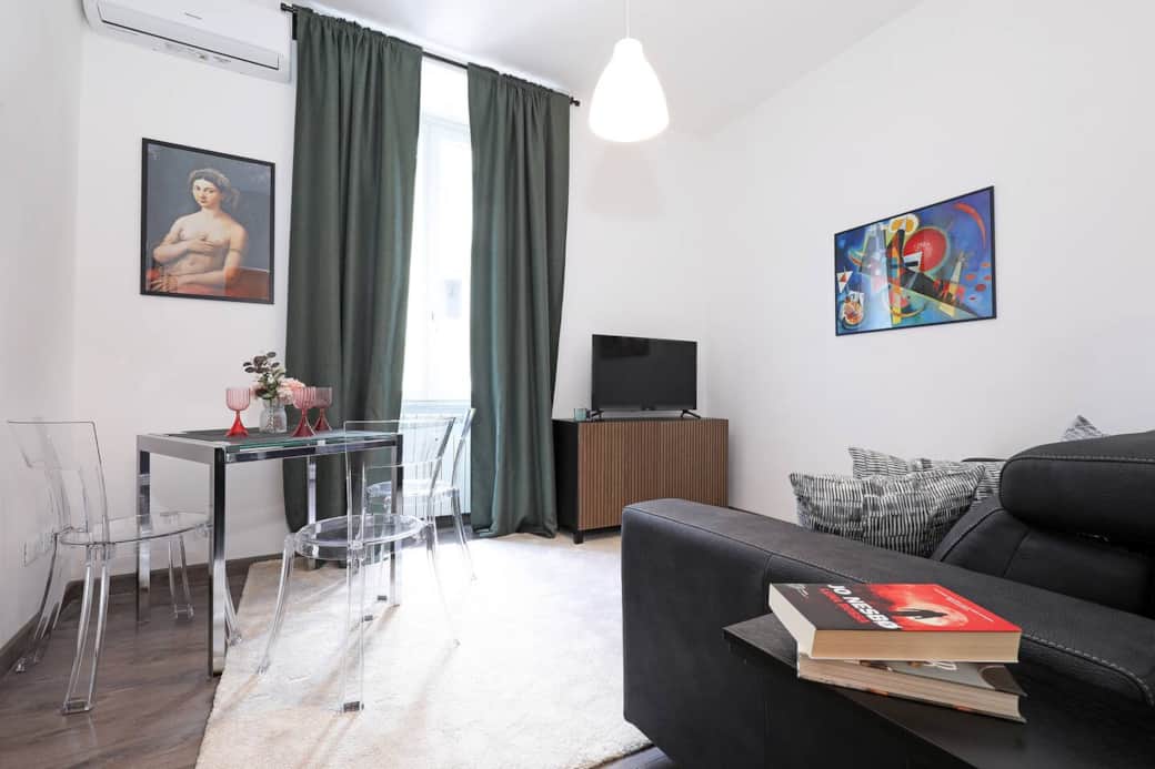 Soggiorno con divano letto alla francese tavolo con sedie smart tv