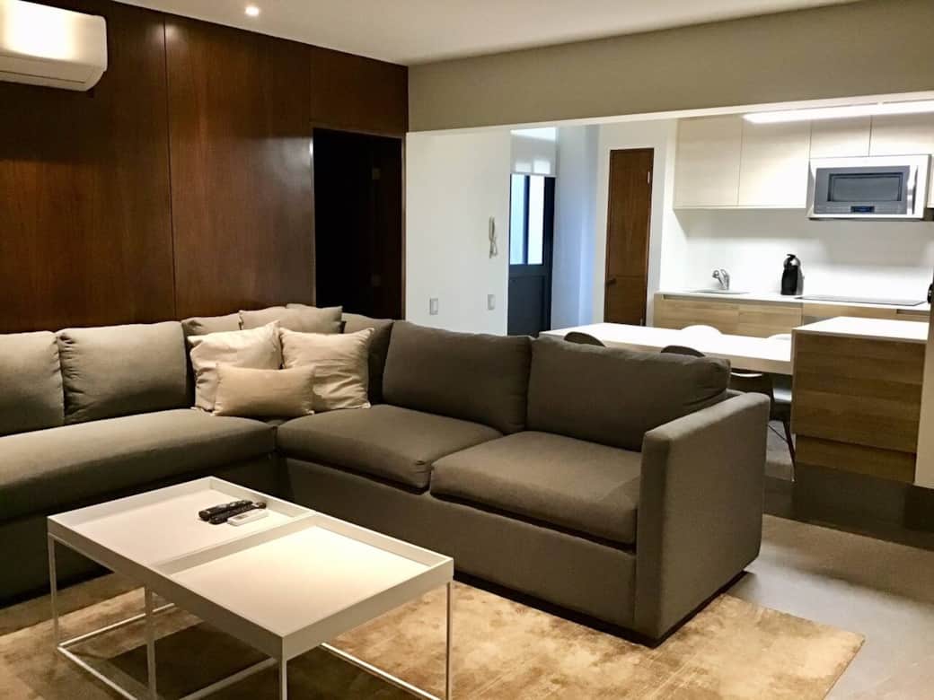Sala amplia con sillones L con mini barra