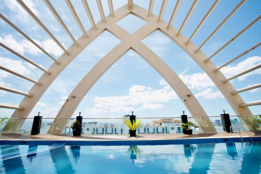 Roofdeck pool with overlooking view of Makati, Pasay, and BGC Skylines.

