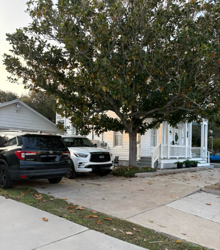 White Magnolia Galveston vacation rental illuminated at night with a welcoming porch and coastal style