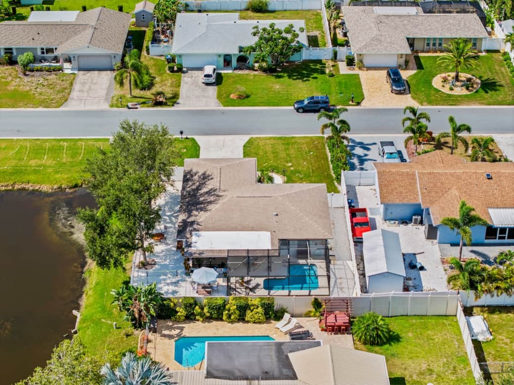 An overhead view of Casita Haven Retreat showcasing the private screened pool, spacious outdoor living area, large driveway, and peaceful neighborhood setting, offering guests both privacy and convenience.