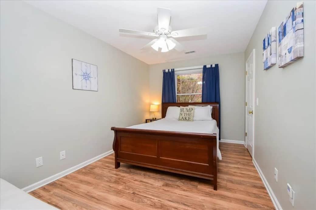 Queen sleigh bed, coastal decor, compass wall art, closet, navy curtains, sleeps 2-3 with single futon, group-friendly, Smith Mountain Lake guest room.