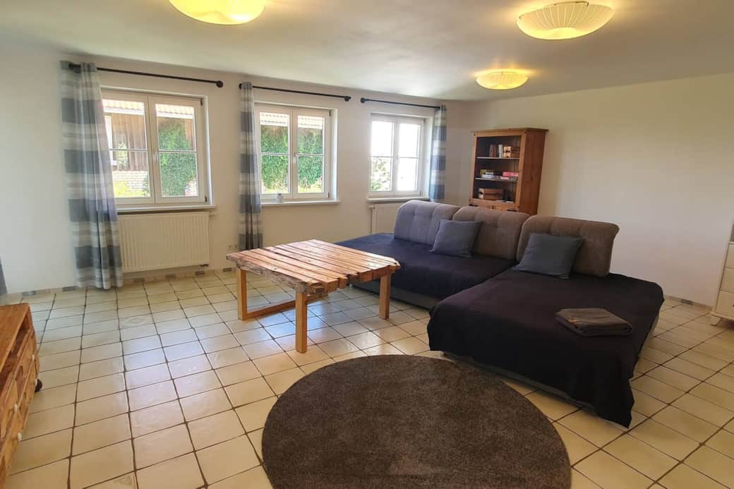 Großer Wohnraum mit Couch und Smart-TV in der Ferienwohnung Beckenhölzle Großer Wohnraum mit Couch und Smart-TV in der Ferienwohnung Beckenhölzle