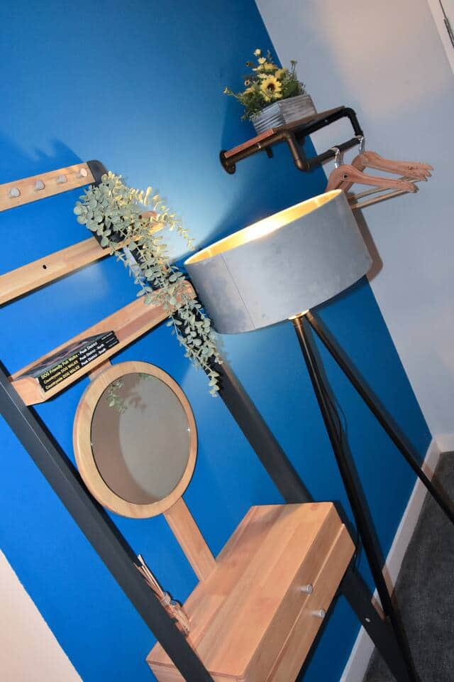 A stylish corner in the third bedroom with a bold blue wall, industrial rail, and compact dressing table. Perfect for getting ready or storing essentials with a touch of character.