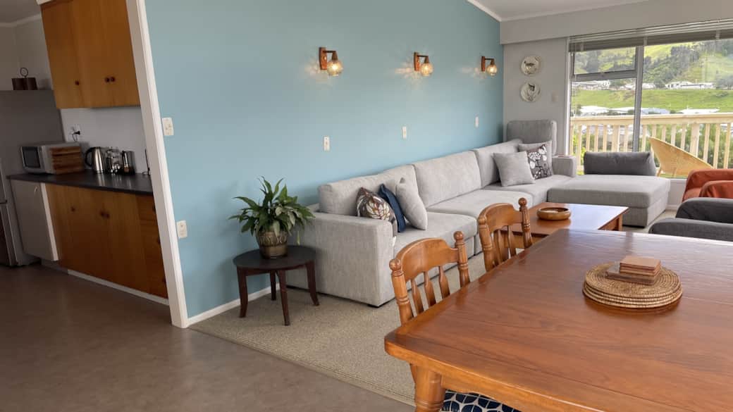 Galley kitchen looks over dining table.