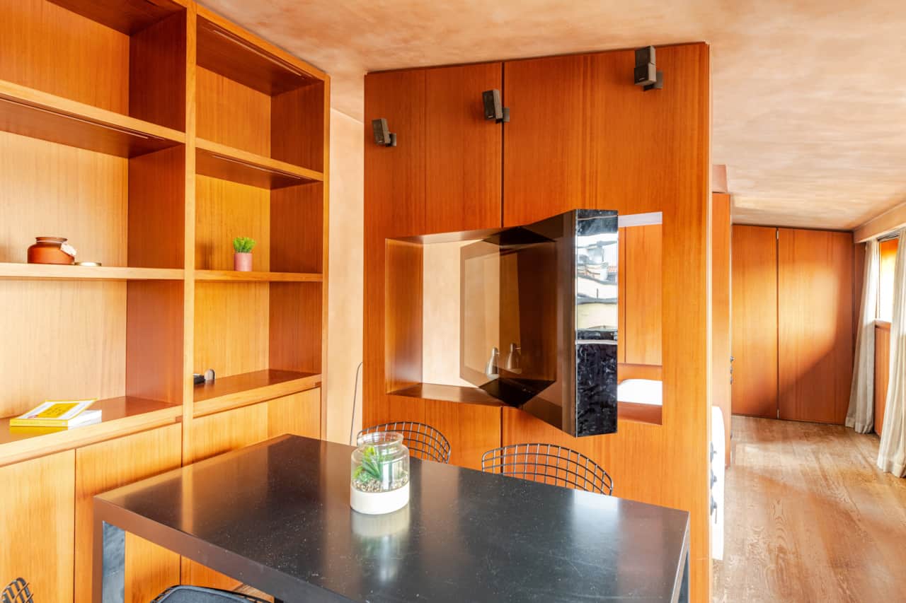 Mesa de comedor con sillas y estantes de pared