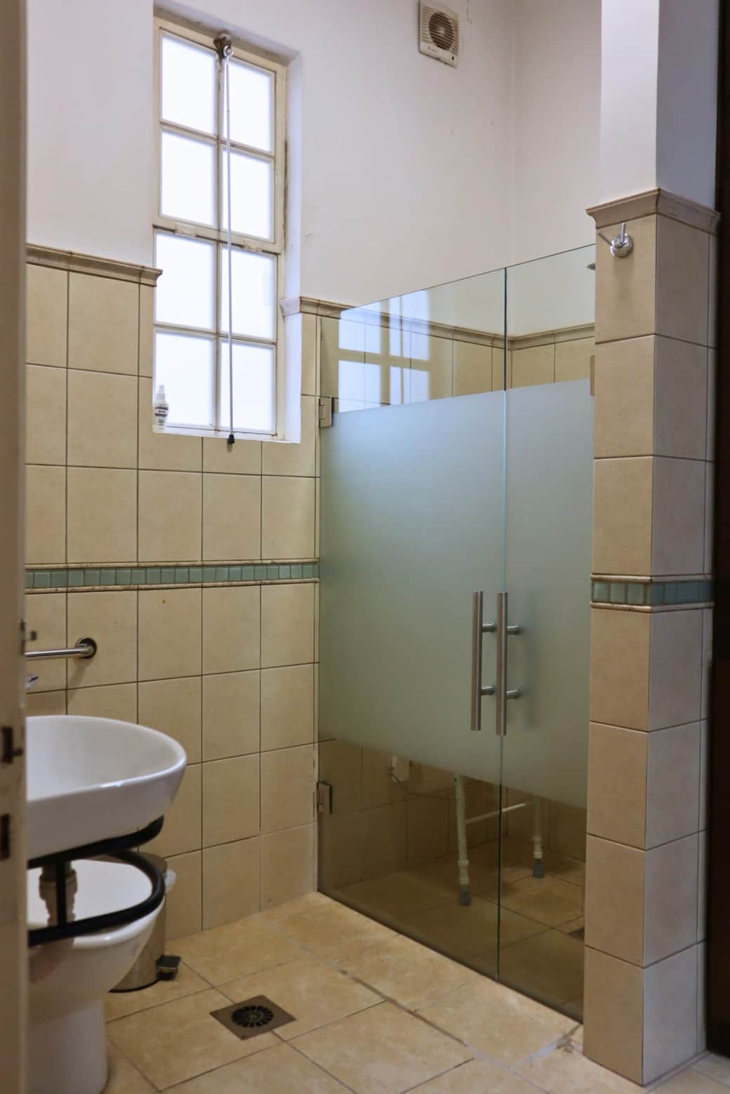 Se instalaron mamparas de vidrio con puertas doble super anchas que se abren de ambos lados para facilitar el acceso en silla de ruedas.
