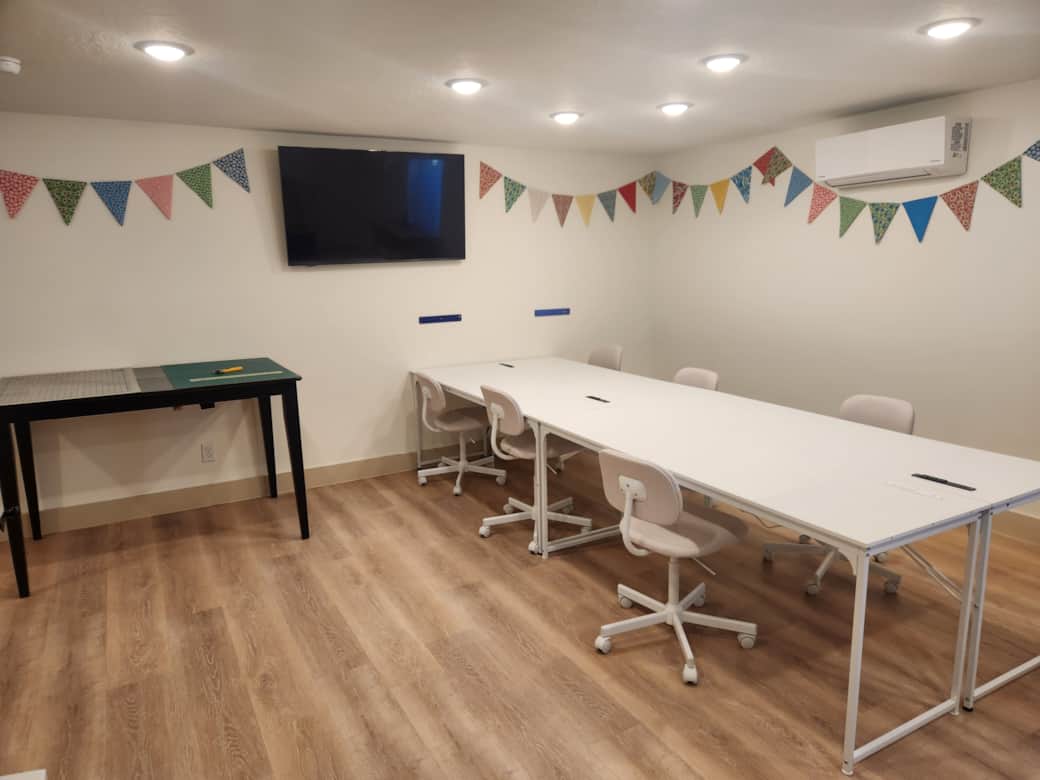 Sewing studio for six has two cutting tables, two ironing stations, and comfortable sewing chairs.